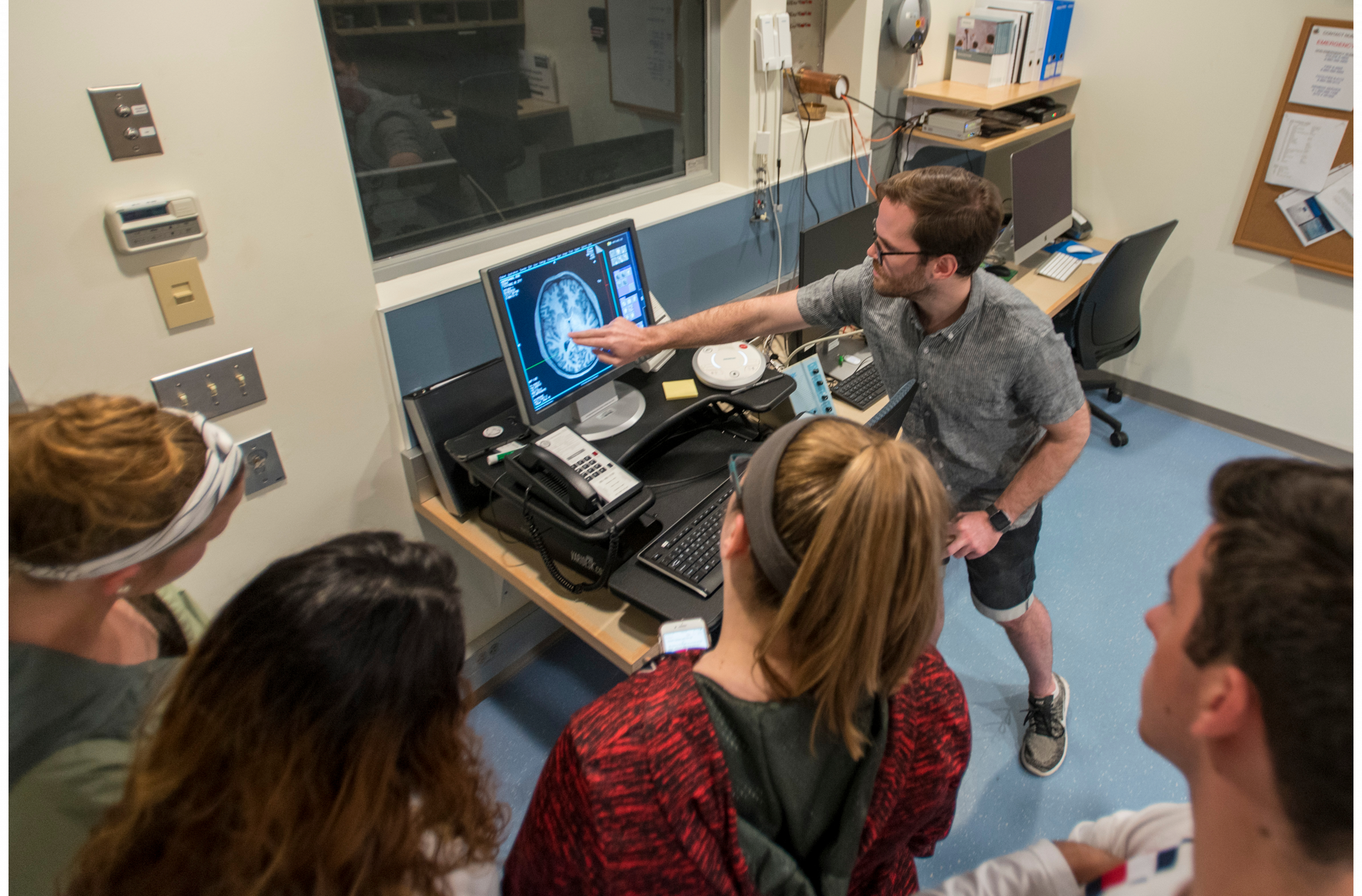 students gather around imaging of a brain scan